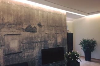 Indirekte Wandbeleuchtung mit Lichtvouten und Tapete im Betonlook